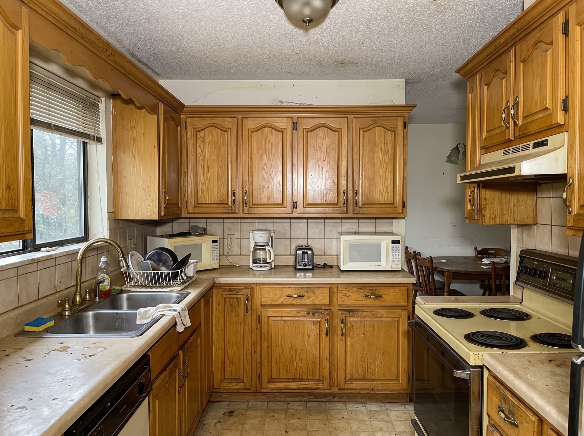 AI kitchen cabinet design comparison: golden oak cabinets from the nineties become navy shaker with brass pulls — before, original kitchen photo